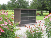 Picture of Columbarium surrounded by flowers and green lawn.